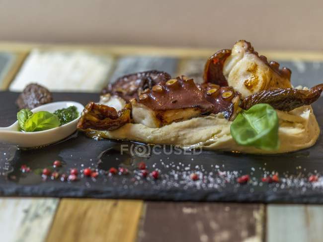Closeup view of octopus pieces on Polenta with basil Pesto — Stock Photo