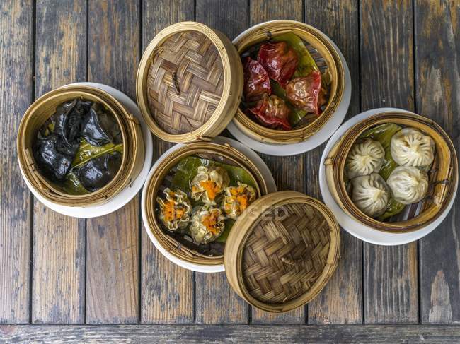 Vista superior de varios dumplings rellenos en vapores de bambú - foto de stock
