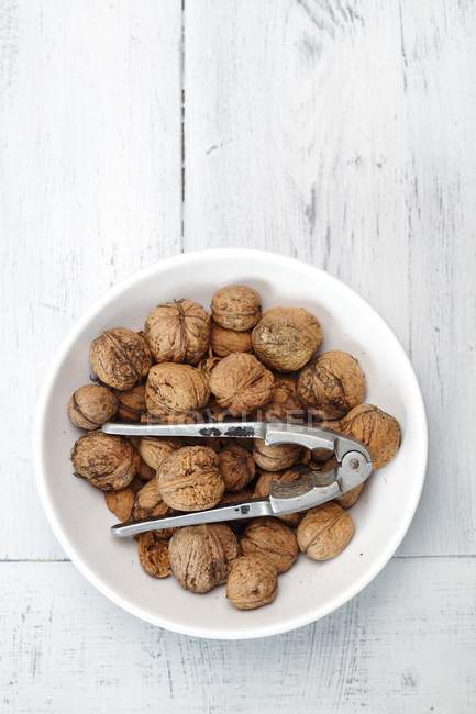 Bowl of walnuts on plate — Stock Photo