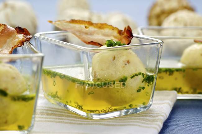 Суп з беконом і пельмені з манною крупою в невеликих скляних мисках — стокове фото