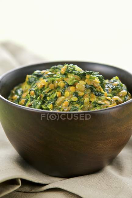 Spinach and lentil stew with oriental spices in black bowl — Stock Photo