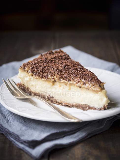 Cheesecake with date caramel on dark surface — Stock Photo
