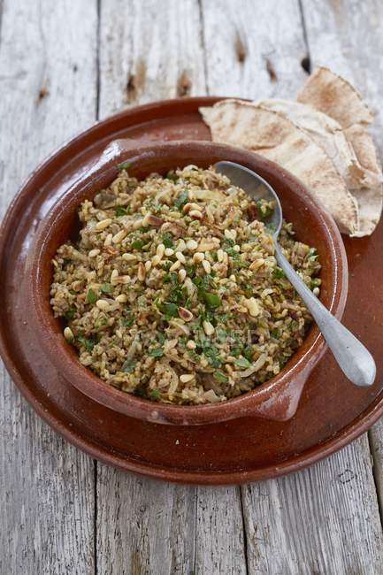 Closeup view of Freekeh pilau with pine nuts and flat bread on plate — Stock Photo