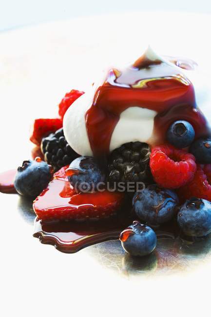 Closeup view of fresh berries with cream and syrup — Stock Photo
