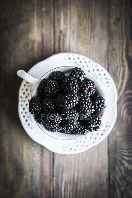 Moras frescas en taza de té - foto de stock