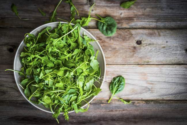 Fresh rocket and spinach in bowl — Stock Photo