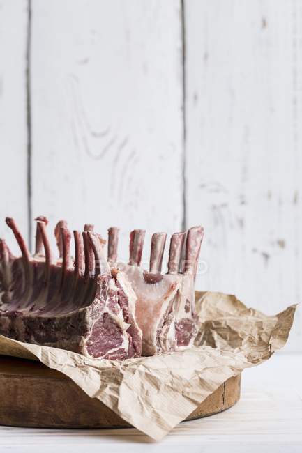 Raw rack of lamb on piece of paper — Stock Photo