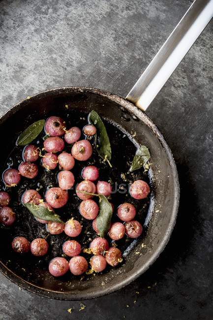 Top view of fried radishes with sage and lemon zest — Stock Photo