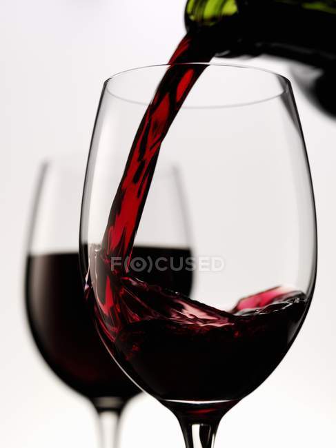 Vinho tinto sendo derramado em vidro — Fotografia de Stock