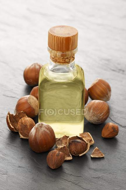 Closeup view of hazelnut oil and hazelnuts — Stock Photo