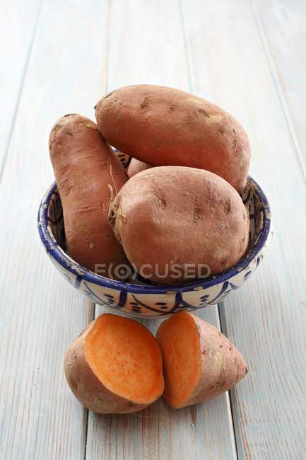 Batatas con mitades en tazón - foto de stock