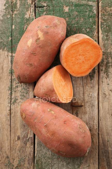 Ganze und halbierte Süßkartoffeln — Stockfoto