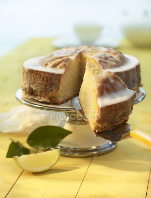 Lemon cake with piece removed — Stock Photo