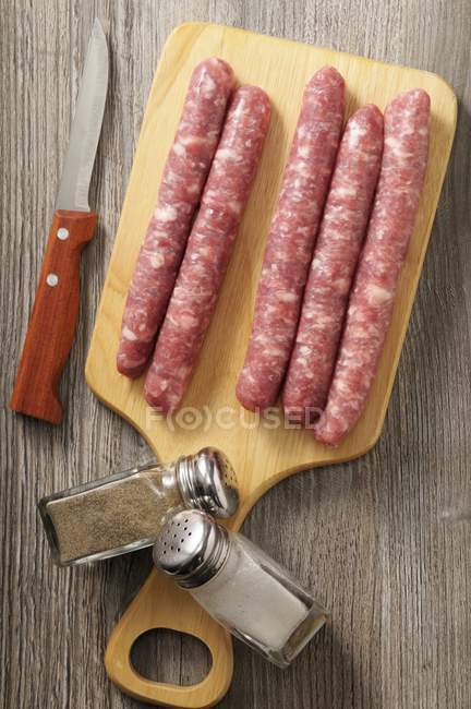 Chipolata sausages on wooden board — Stock Photo