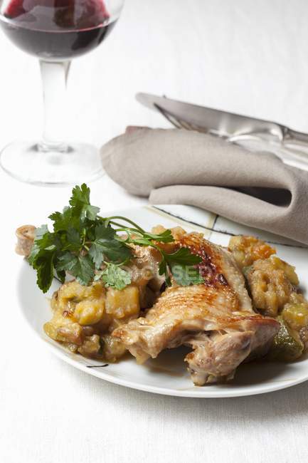 Chicken leg with braised vegetables on white plate — Stock Photo