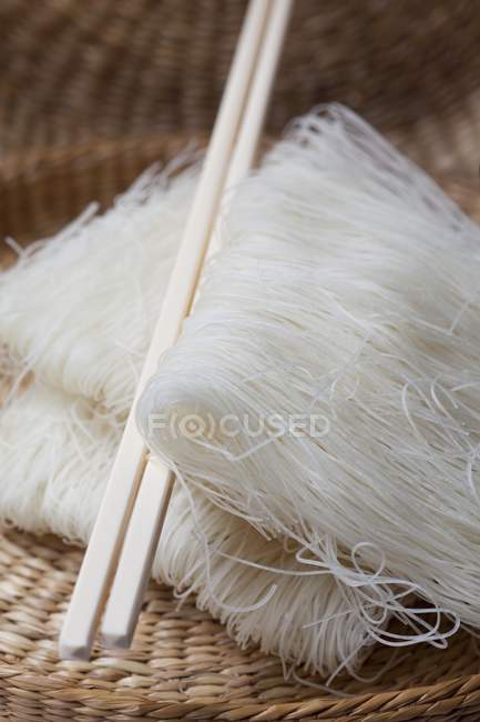 Closeup view of glass noodles and chopsticks in a wicker basket — Stock Photo
