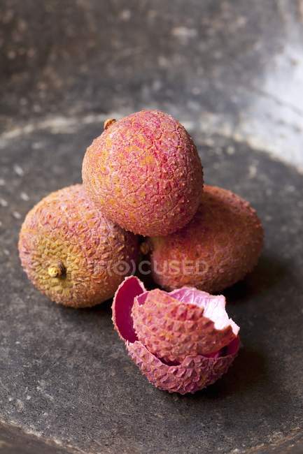 Lychees in grey stone bowl — Stock Photo