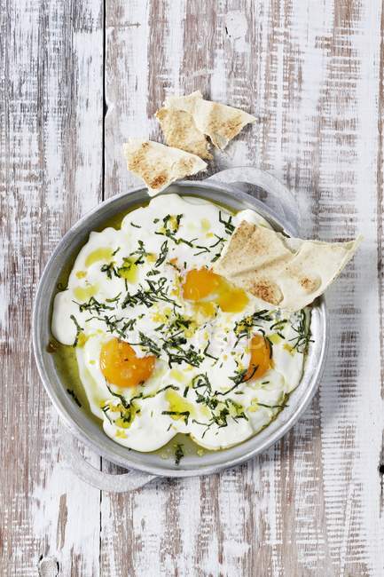 Fried eggs with garlic yogurt — Stock Photo