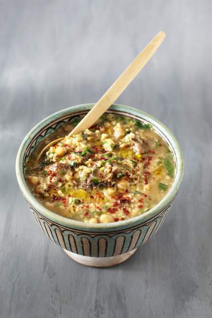 Soupe freekah épicée aux pois chiches en pot sur une surface grise — Photo de stock