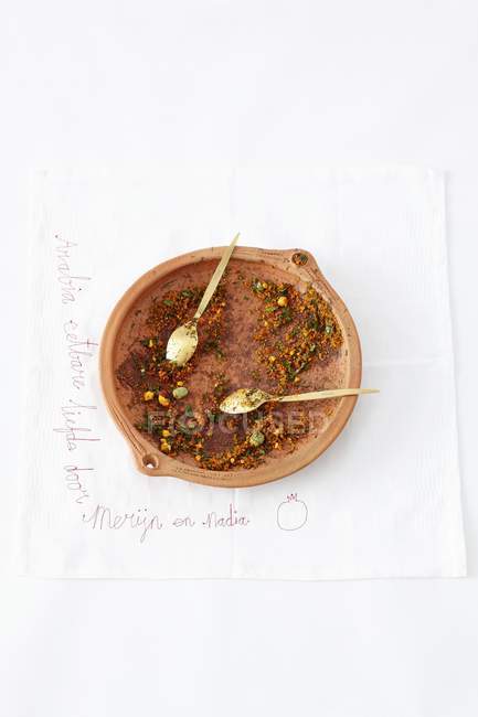 Vue du dessus des restes d'un plat arabe dans un bol en terre cuite sur fond blanc — Photo de stock