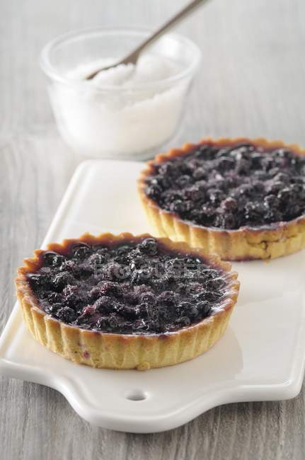 Blueberry tartlets on cutting board — Stock Photo