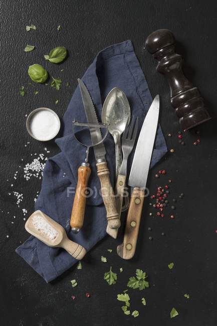 Top view of an arrangement of cutlery, a napkin, herbs and spices — Stock Photo