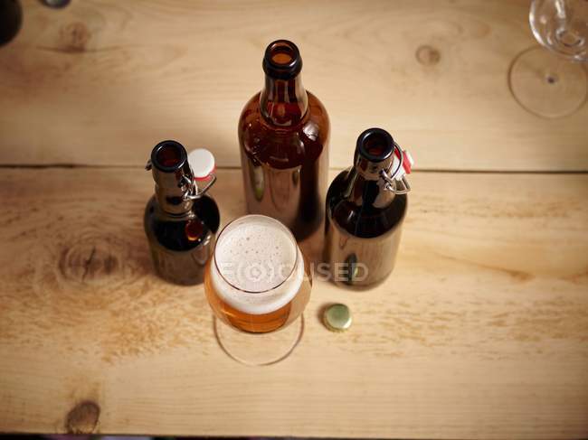 Vaso de cerveza y botellas - foto de stock