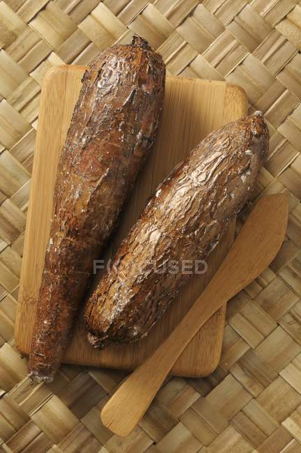 Manioc sur une planche de bois sur une surface de paille — Photo de stock