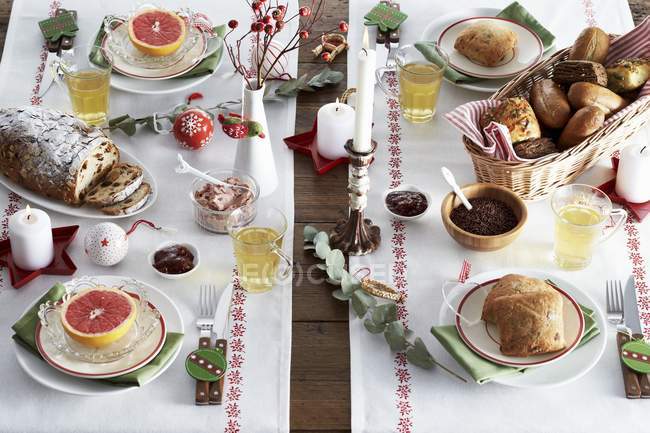 Підвищені подання накритий стіл з булочки, фруктові пюре, кров апельсини і різдвяні прикраси — стокове фото