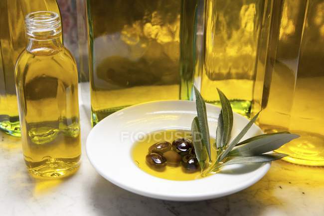 Botella de aceite de oliva y aceitunas - foto de stock