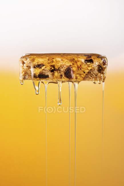 Honey being poured over muesli bar — Stock Photo