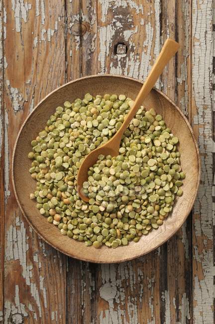 Split peas in a wooden bowl with a wooden spoon — Stock Photo