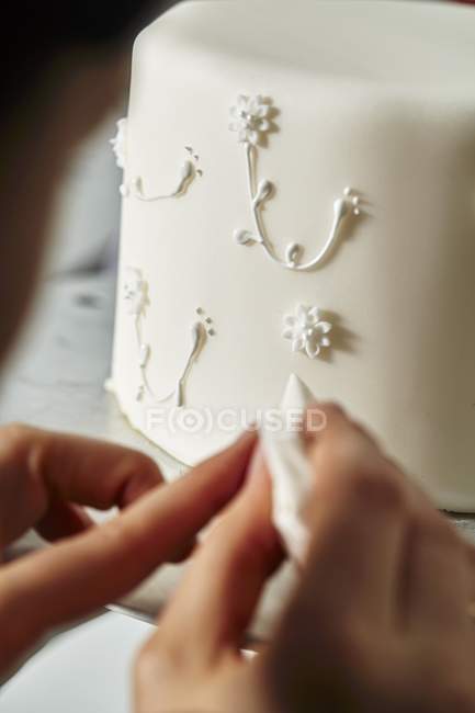 Confitero decorando un pastel de boda - foto de stock