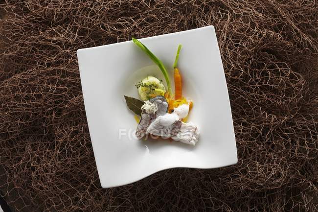 Poached Lake Constance hake on a bed of root vegetables with mashed potatoes and a horseradish — Stock Photo