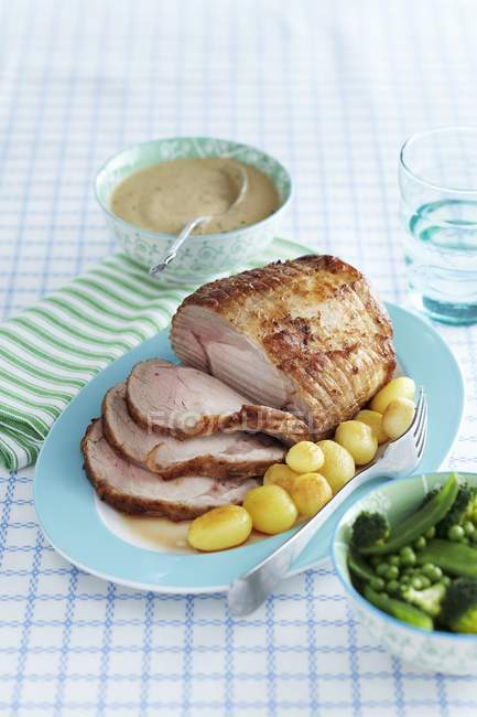 Roasted pork with potatoes and green vegetables — Stock Photo