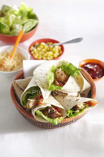 Tortilla wraps with chicken and vegetables on white surface — Stock Photo