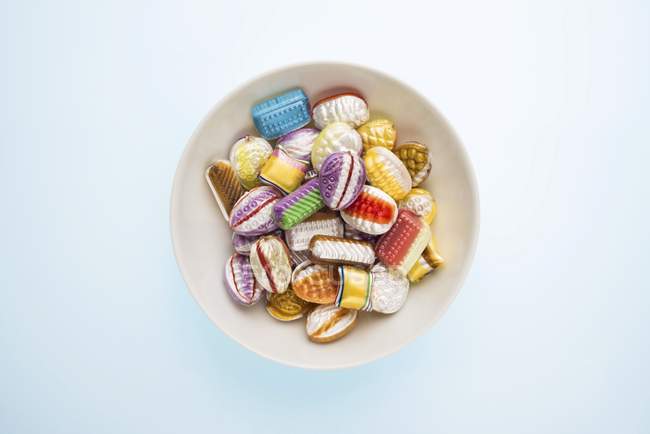 Vista dall'alto di dolci misti in ciotola bianca su superficie blu — Foto stock
