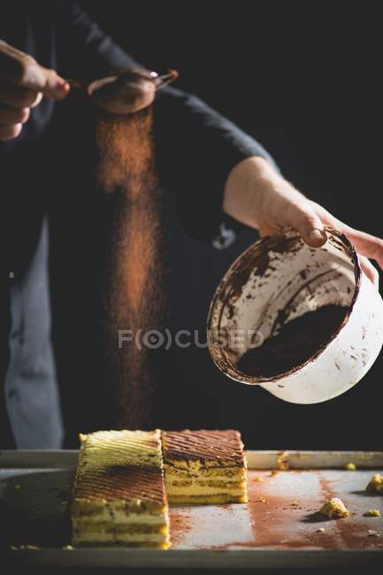 Tiramisu slices being dusted — Stock Photo
