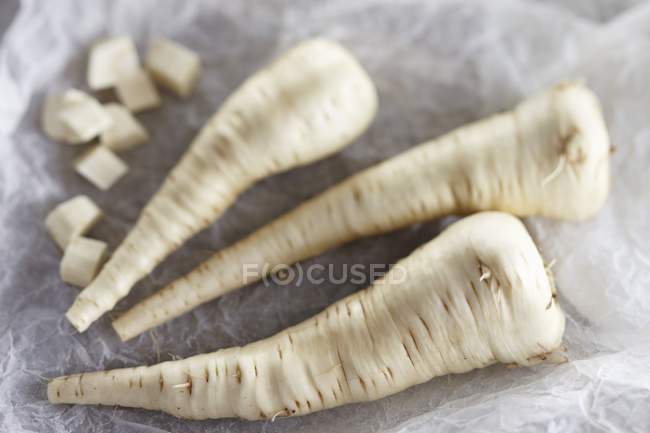 Pastinache fresche intere e tagliate a dadini — Foto stock