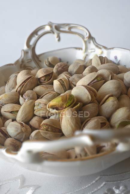 Pistachios in porcelain bowl — Stock Photo