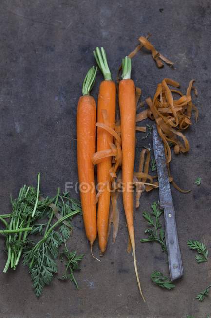 Peeled carrots with knife — Stock Photo