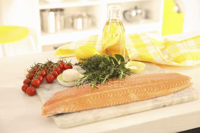 Salmon, herbs on wooden desk — Stock Photo