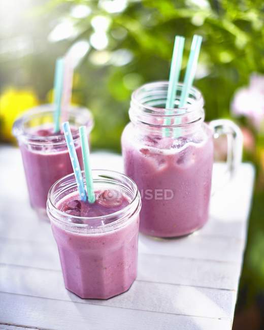 Smoothies on table in garden — Stock Photo