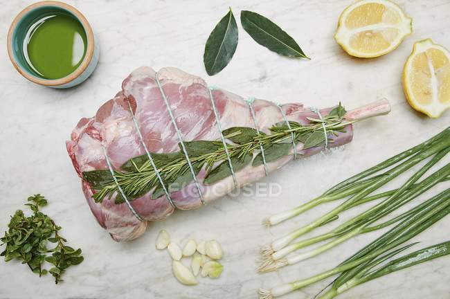 Perna crua de cordeiro com ingredientes — Fotografia de Stock
