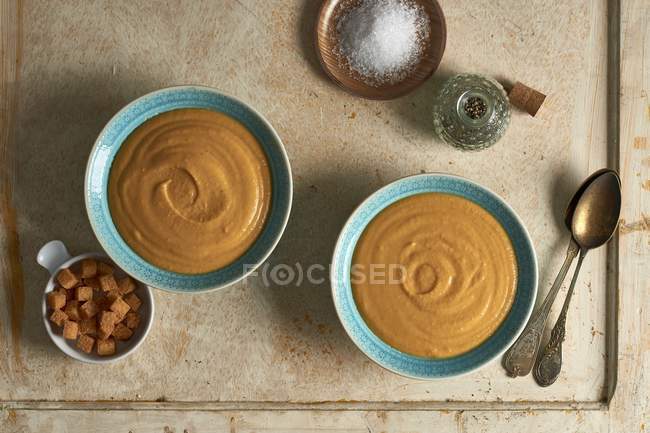 Creamy carrot soup in bowls with croutons — Stock Photo