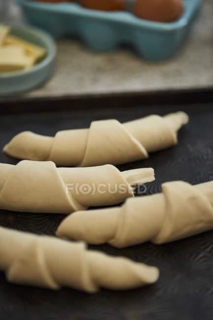 Croissants non cuits sur une plaque à pâtisserie — Photo de stock