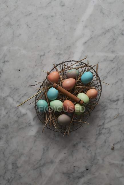 Easter eggs in wire basket — Stock Photo