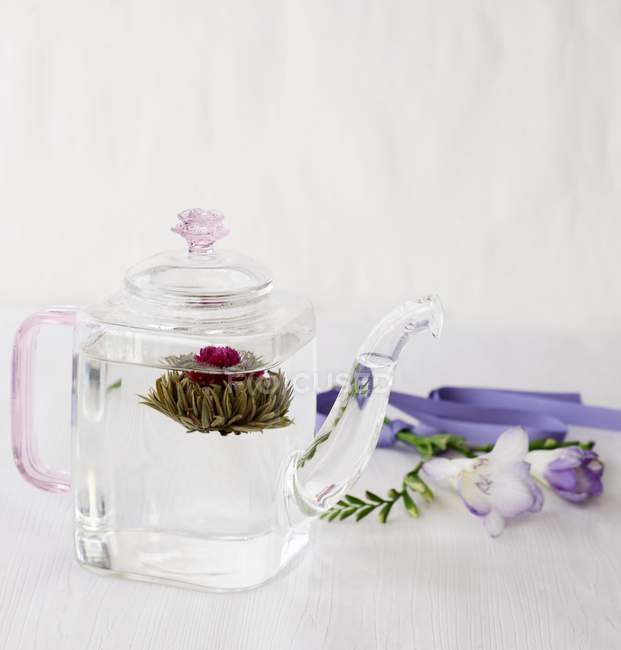 Flor del té en tetera de vidrio - foto de stock