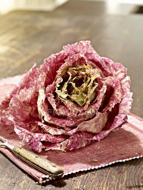Radicchio chioggia on a place mat on wooden surface — Stock Photo