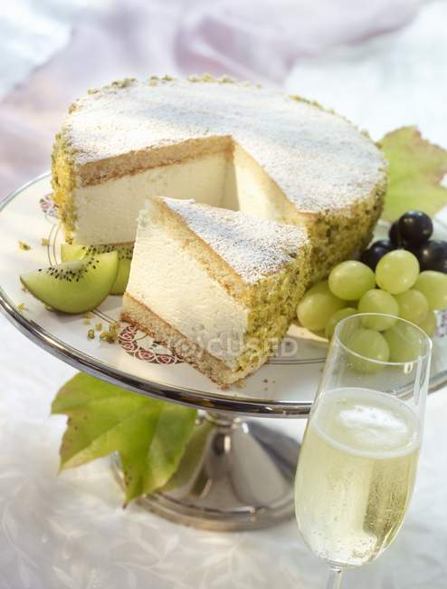 Cheesecake garnished with kiwis and grapes — Stock Photo